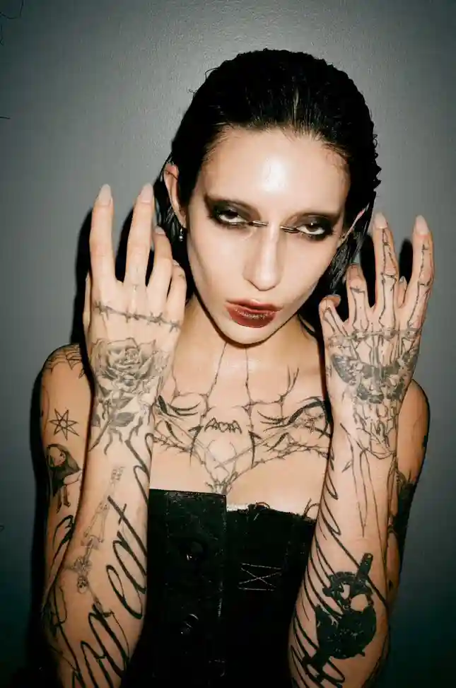 DeathByRomy close up shot showing tattoos