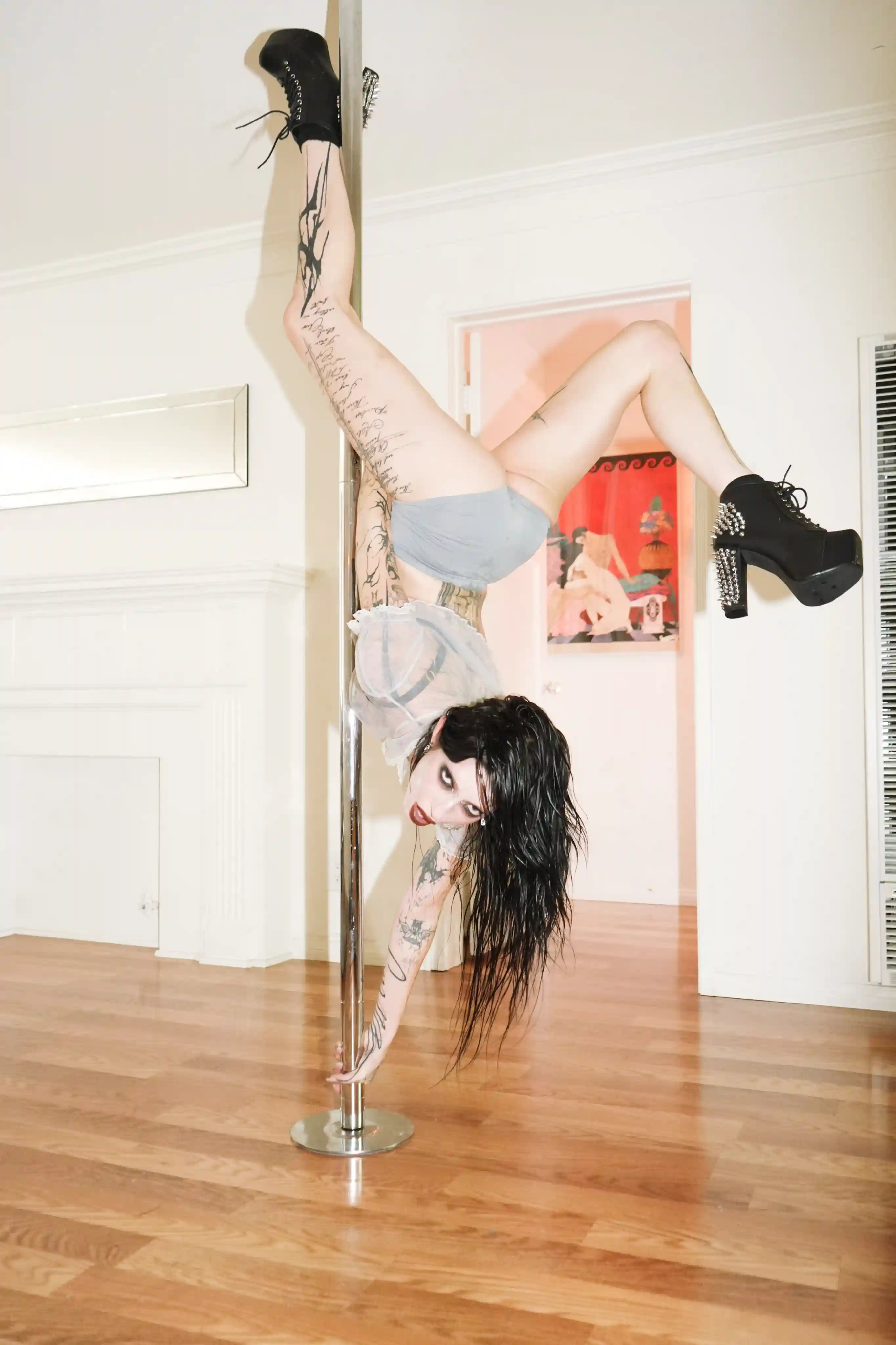 DeathByRomy in pole upside down looking at the camera