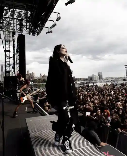 DeathByRomy in front of a crowd holding a mic